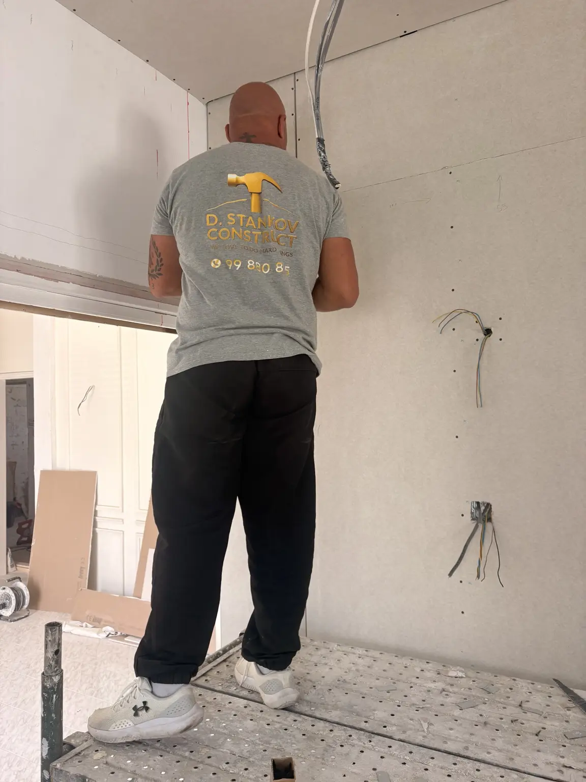 D. Stankov Construct team member installing gypsum board